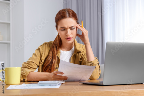 Woman doing taxes at table in room