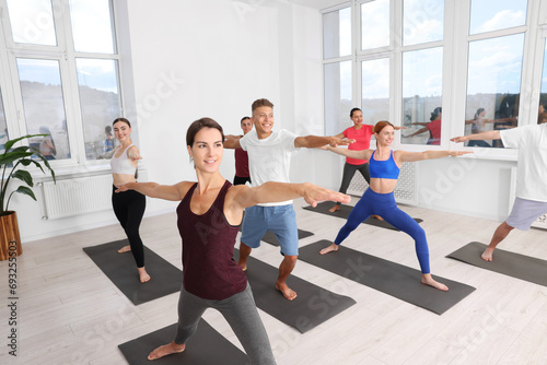 Fototapeta Naklejka Na Ścianę i Meble -  Group of people practicing yoga on mats indoors