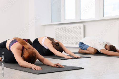 Group of people practicing yoga on mats indoors