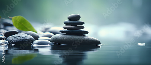 A few stones and a green leaf on the calm water surface in a minimalist composition reflect Zen and tranquility 2