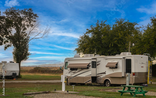 Rv motorhome and camper parked at campsite on grass