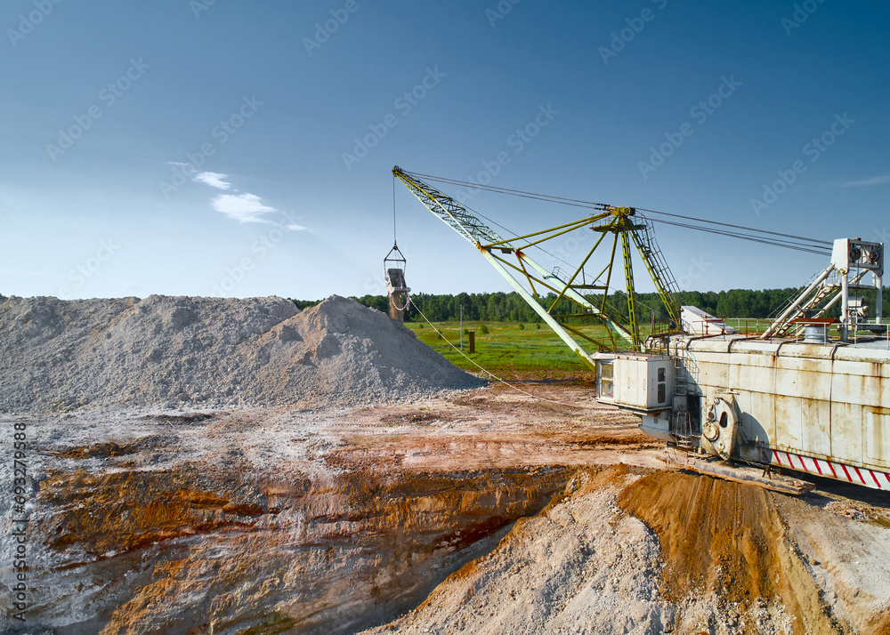 Walking excavator takes chalk with bucket in open quarry Walking excavator takes chalk with bucket in open quarry