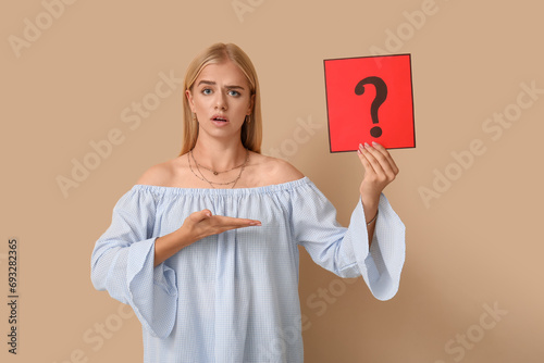 Confused young woman holdin...