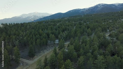 Drone over pine trees and homes leading up to Mount Princeton in the Rocky Mountains in Colorado photo
