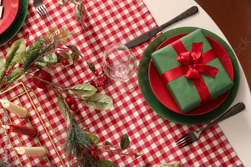 Table setting with Christmas decorations and gift in living room