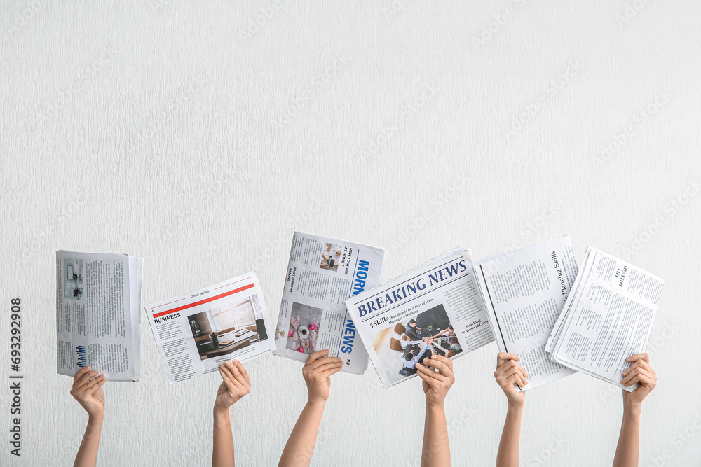 Female hands with different newspapers against light background - obrazy, fototapety, plakaty 