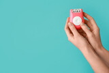 Female hands with modern epilator on turquoise background