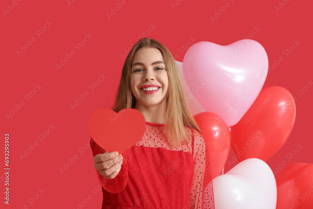 Pretty young woman with paper heart and balloons on red background. Valentine's Day celebration Pretty young woman with paper heart and balloons on red background. Valentine's Day celebration