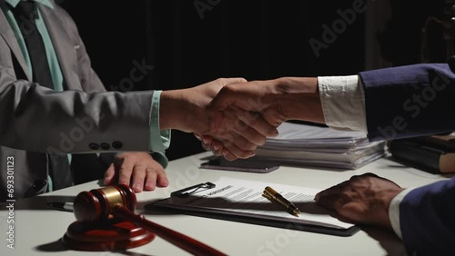 Businessmen shaking hands with a lawyer to accept an agreement with a lawyer, partner, or lawyer discussing contract agreement in financial business, bank, with the hammer of justice. photo