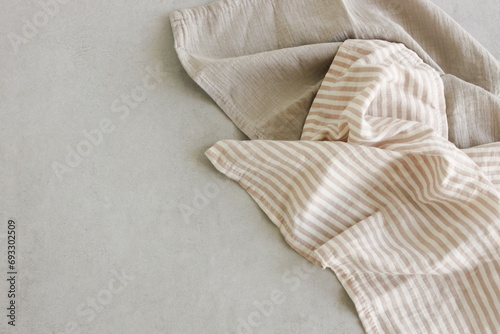 Llinen napkins beige color top view on gray stone background with copy space. Brand template, Neutral colors
