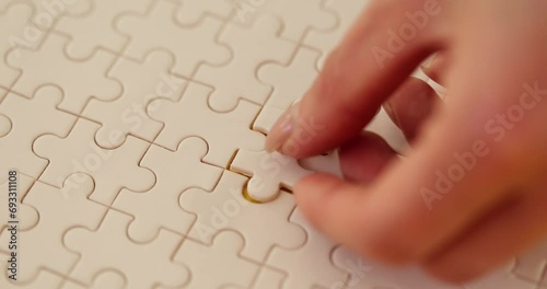 Female hand putting last missing piece of puzzle closeup photo