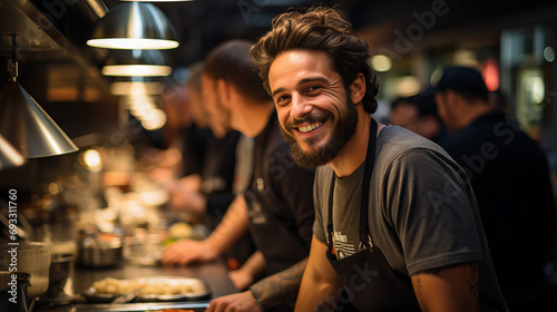 A well-dressed man radiates joy as he confidently poses in an upscale restaurant kitchen, embodying the perfect blend of sophistication and warmth