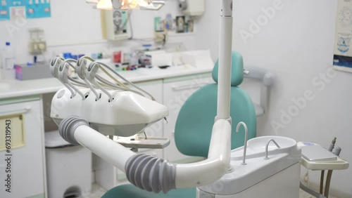 Side view of a modest dental clinic without people showing the dentist's equipment necessary to treat oral ailments. Dentist's profession concept photo