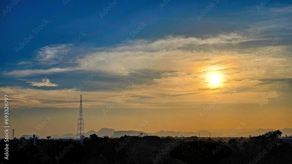 Naklejka premium Silhouettes of the electric power masts and cables, Pylons against sunset over countryside. The sunset and electrical network. High-voltage power lines at sunset. Electricity distribution station.