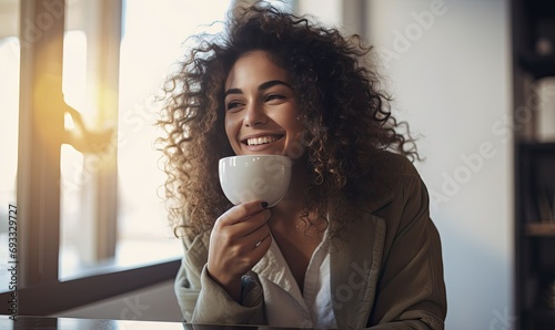 A woman sitting at a table with a cup of coffee photo