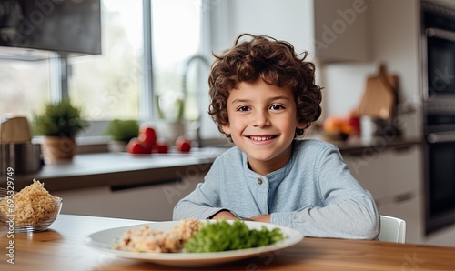 A little boy sitting at a table with a bowl of cereal and a glass of