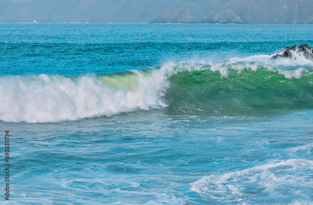 Wave splashes close-up. Crystal clear sea water hitting rock formations in the ocean in San Francisco Bay, blue water, pastel colors. Wave splashes close-up. Crystal clear sea water hitting rock formations in the ocean in San Francisco Bay, blue water, pastel colors.