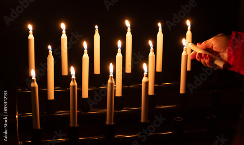 Foto fire up a candle with a hand, cluster of candles