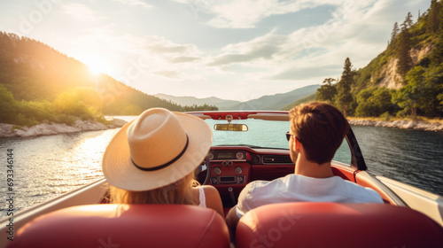 Back wide view of happy caucasian couple on a roadtrip in Europe driving modern cabriolet car in picturesque place photo