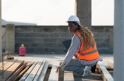 Young female architect working on a construction site with a laptop in her hands