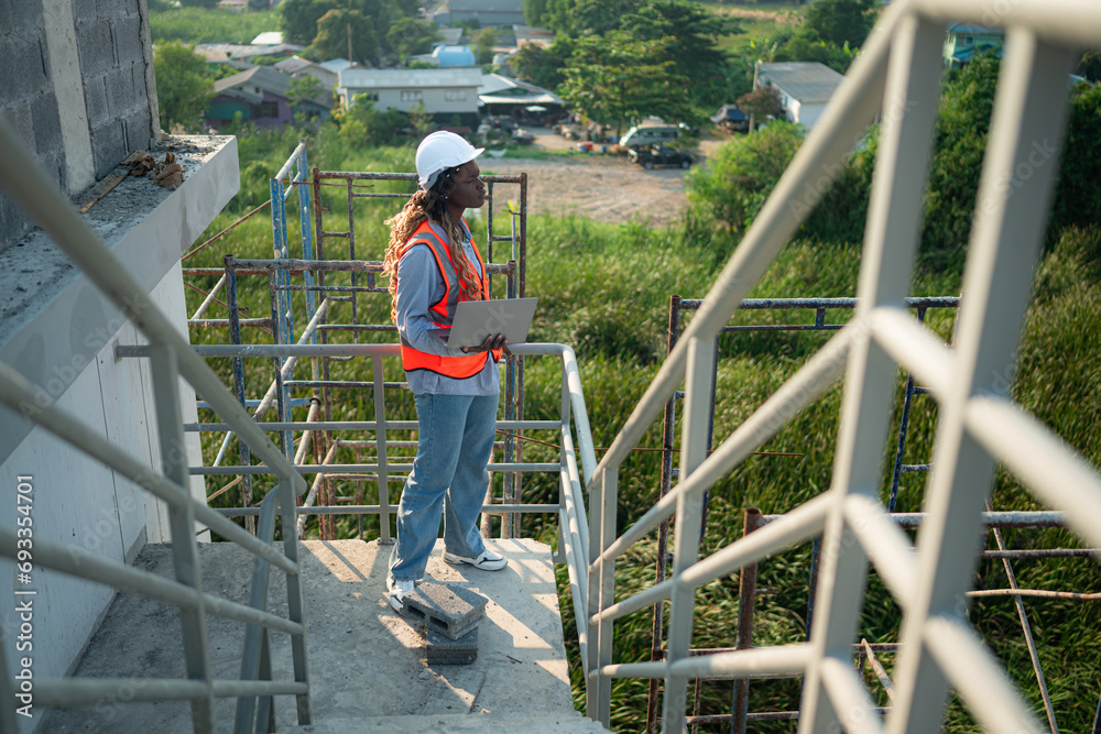 Young female engineer or architect working on construction site