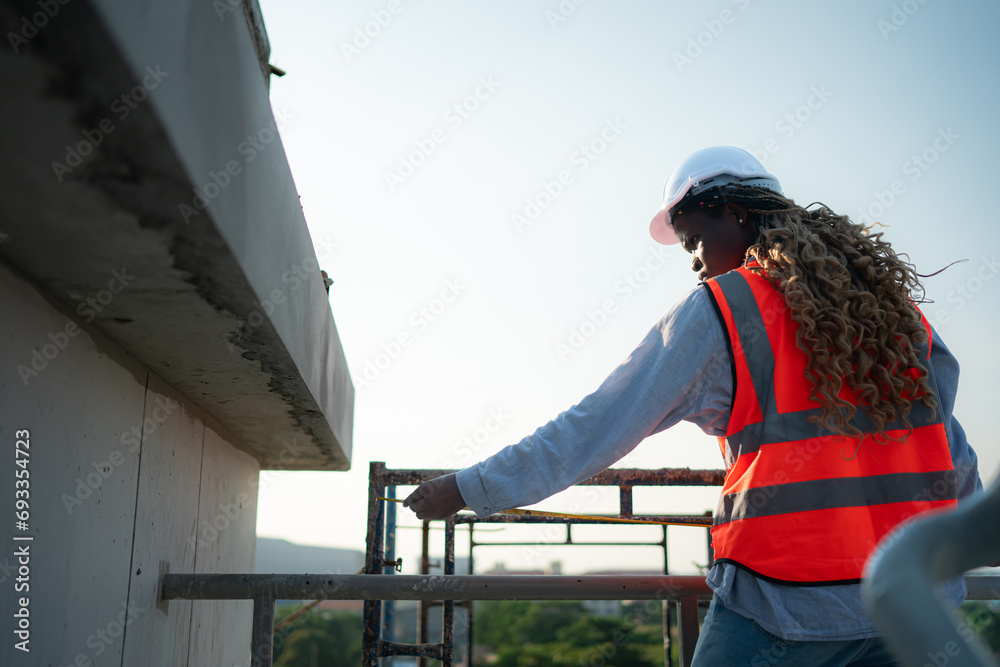 Young female engineer or architect working on construction site