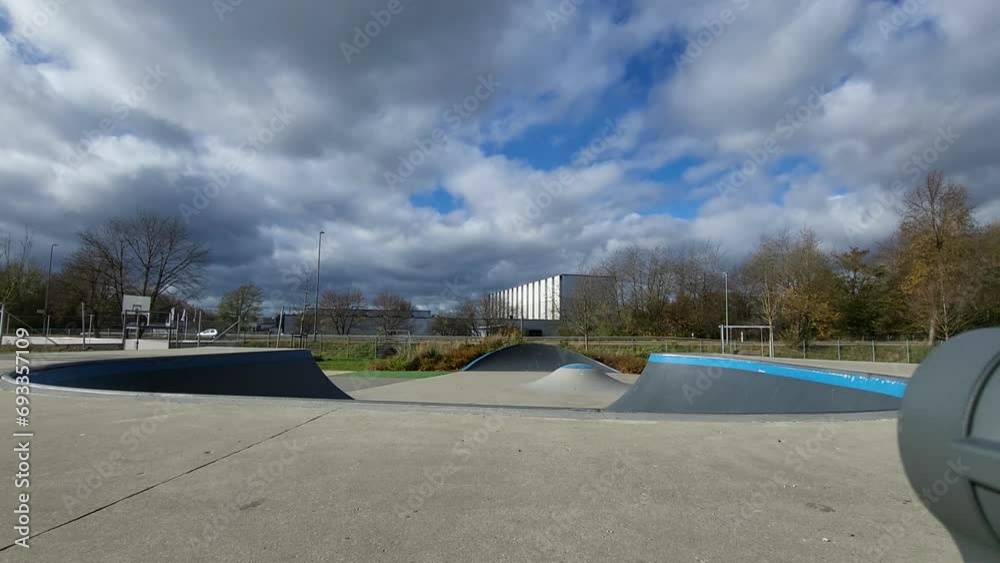 Ein Mann, der mit Inlineskates auf einer Halfpipe in einem Skatepark fährt. Der Mann trägt einen Helm und führt einen Trick aus. Die Rampe ist aus Holz und gebogen.