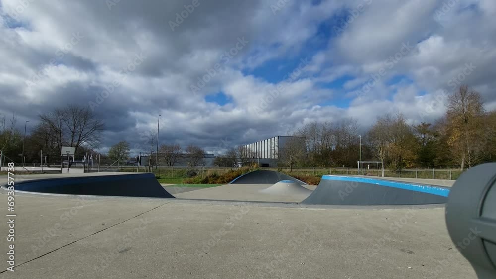 Ein Mann, der mit Inlineskates auf einer Halfpipe in einem Skatepark fährt. Der Mann trägt einen Helm und führt einen Trick aus. Die Rampe ist aus Holz und gebogen.