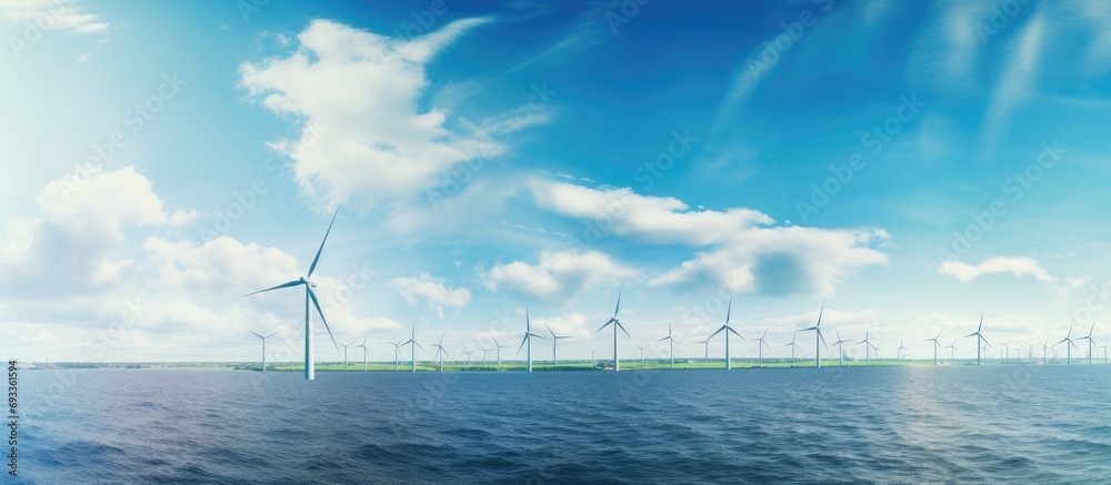 Sunny day in the Netherlands with offshore windmill park on ocean, green energy.