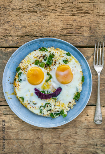 sunny side up fried egg with smiling face shape on plate