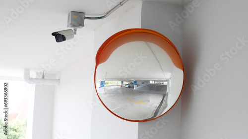 The curved glass with securit camera is installed at the corner of the parking building to prevent accidents from driving in the opposite direction photo