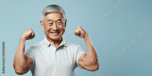 An older man showcasing his strength by flexing his muscles on a vibrant blue background. Perfect for fitness and health-related concepts