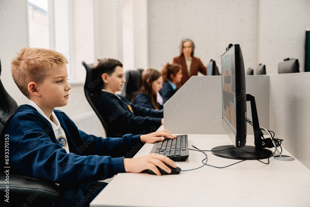 © Drobot Dean - Group of children using personal computers during computer science class at school