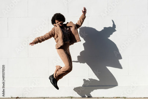 Carefree young woman jumping in the street.