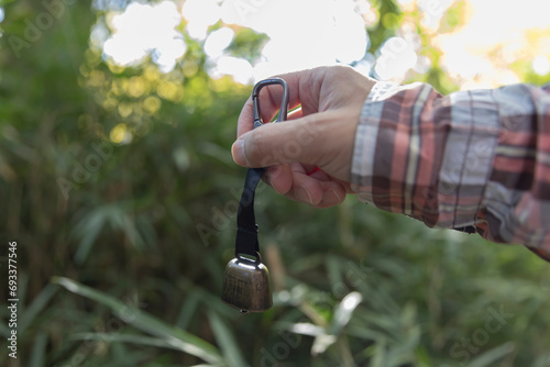 A bear bell with hand at the green forest in Autumn