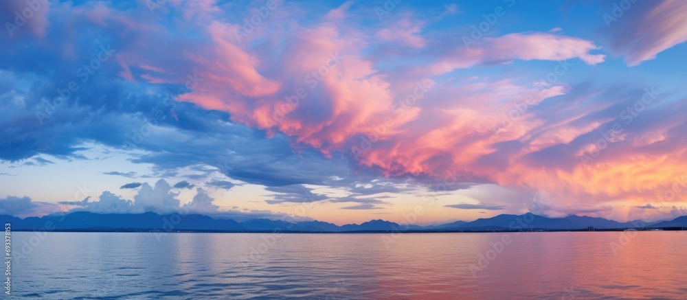 Picturesque spectacular colorful sky at sunset or dawn with dark blue clouds and pink lighting.
