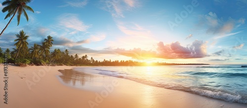Panoramic tropical beach with soft sand, calm sunset sky, and a peaceful summer ambiance.