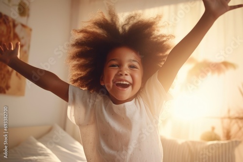 A playful image of a little girl jumping on a bed. Perfect for capturing the joy and energy of childhood. Ideal for use in advertisements, children's books, or parenting blogs photo