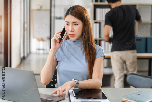 Woman talk mobile phones and working on laptop computers, online business, work from home, teleworking concept.