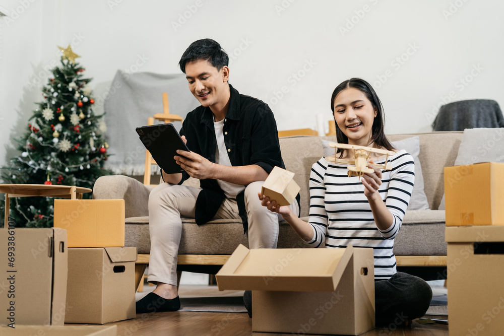 Young couple relaxing sitting on the floor around cardboard boxes at home, smiling happy moving to a new house. Young couple relaxing sitting on the floor around cardboard boxes at home, smiling happy moving to a new house.