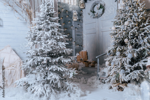 Background of snow-covered fir trees. Studio decor. Door and snow-covered porch against a background of winter trees