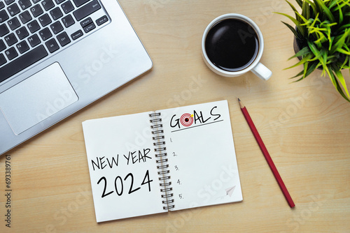 2024 Happy New Year Resolution Goal List and Plans Setting - Business office desk with notebook written about plan listing of new year goals and resolutions setting. Change and bliss concept.