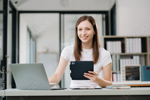 Confident business expert attractive smiling young woman holding digital tablet on desk in office..