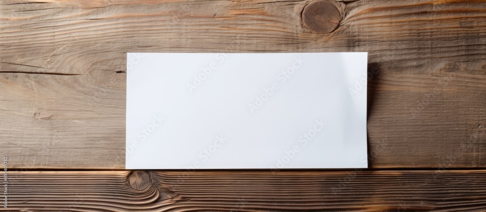 Women hold white trifold paper on wooden texture. - obrazy, fototapety, plakaty 