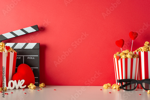 Love story premiere on Valentine's. Side view table set with clapperboard, 3D spectacles, striped popcorn boxes, sprinkles. Hearts and red wall create romantic ambiance for unforgettable memories photo