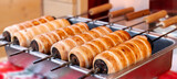 Spit cakes at Christmas Fair close-up. Chimney Cake Hungarian Christmas street food.