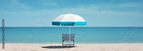 An umbrella and a lazy chair summer vacation getaway on the beach with blue sky background