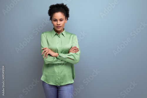 charming young brunette hispanic woman dressed in a green blouse on the background with copy space. people lifestyle concept