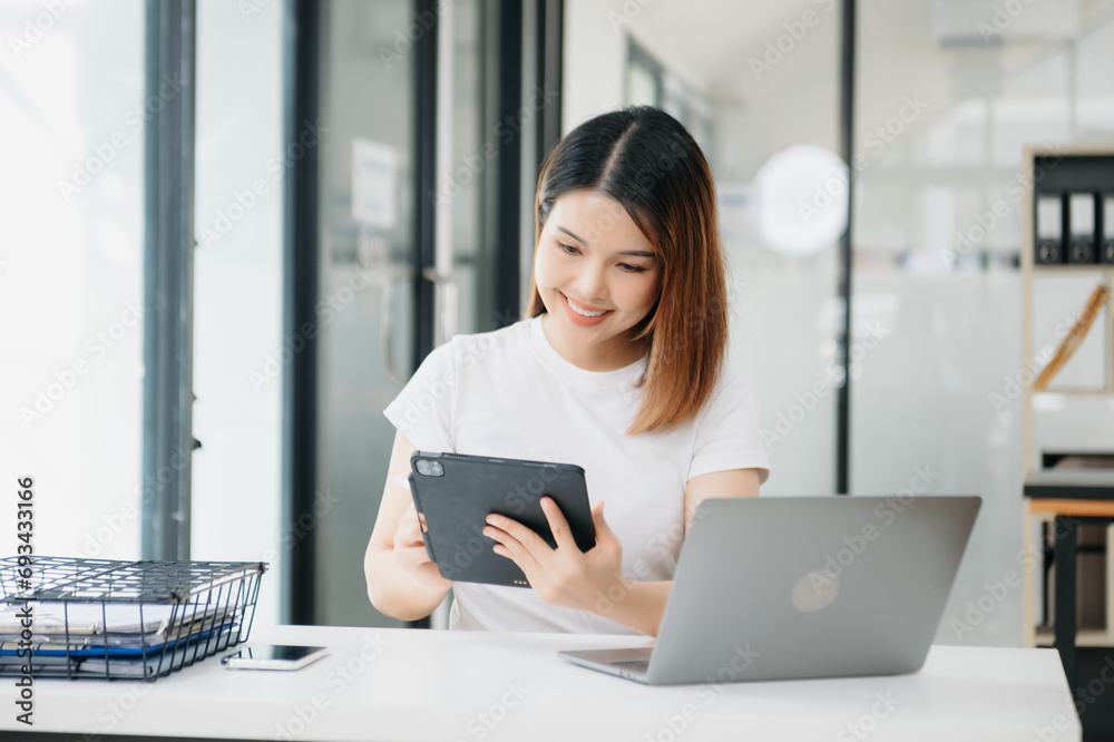 Asian businesswoman working with working notepad, tablet and laptop documents . Asian businesswoman working with working notepad, tablet and laptop documents .