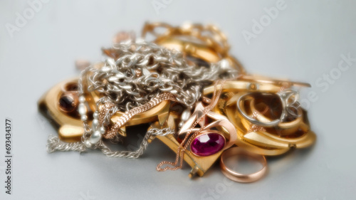 Old and broken jewelry, watches of gold and gold-plated lies in a pile. A scrap of precious metals In soft focus. Selective focus.